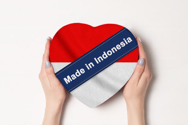 铭文印度尼西亚制造印度尼西亚国旗。女人的手拿着一个心形的盒子。白色背景。图片下载