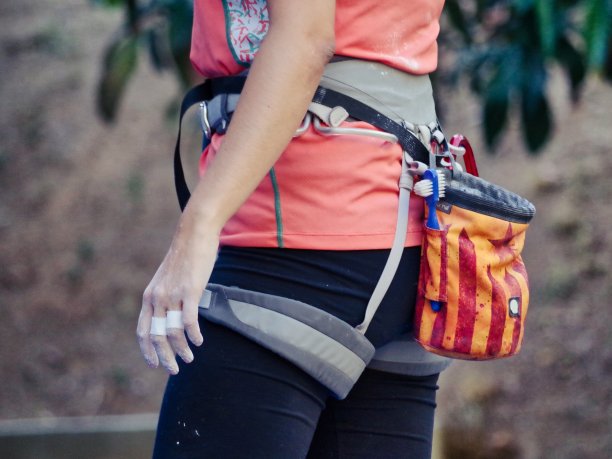 年轻的攀爬妇女准备她的下一个行动在爬墙的粉笔在她的手图片下载