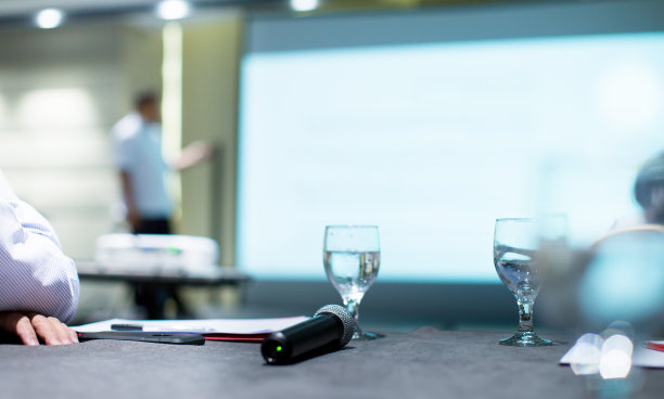 在公司会议上由专业演讲者登台演讲。执行经理在企业家领导工作坊上向观众作报告。主持人给予人们教育。图片下载