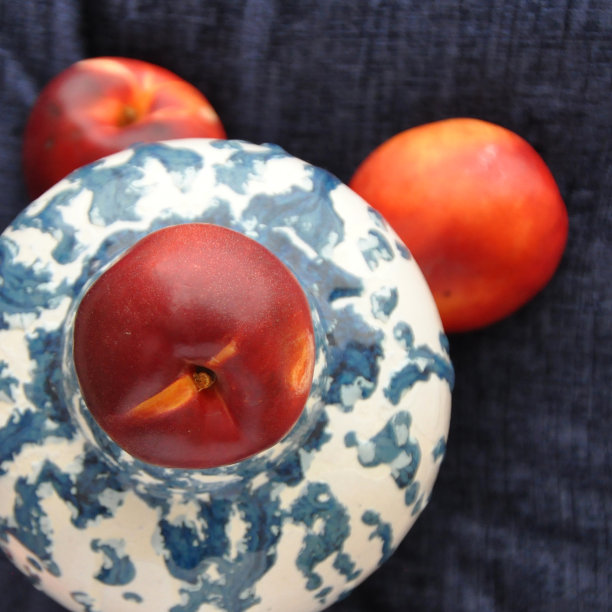 三个油桃配上蓝色的背景图片下载