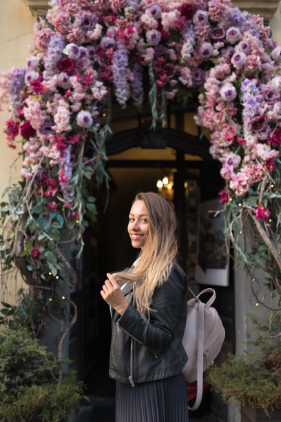 幸福女人肖像性感移动在美丽的里加老城的花拱门背景图片下载