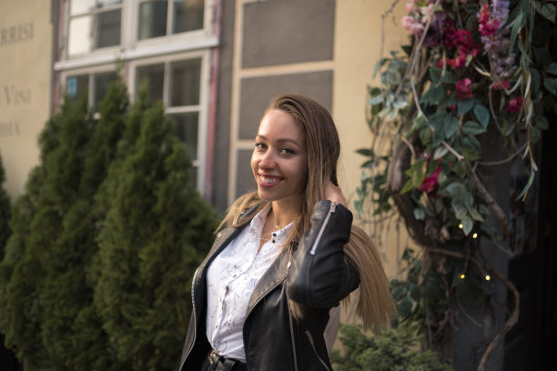 幸福女人肖像性感移动在美丽的里加老城的花拱门背景图片下载