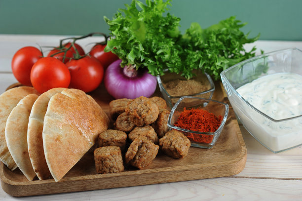 制作口袋饼与蔬菜食材素材：口袋饼、肉丸、番茄、红洋葱、生菜、香料和酱汁图片下载