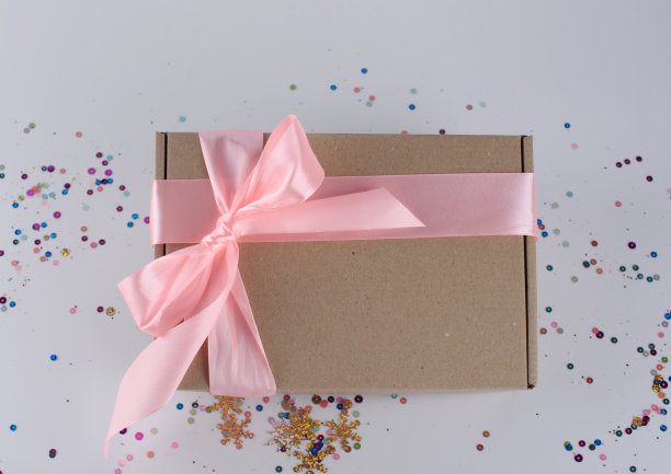 礼盒与粉红色丝带在一个轻的背景图片下载