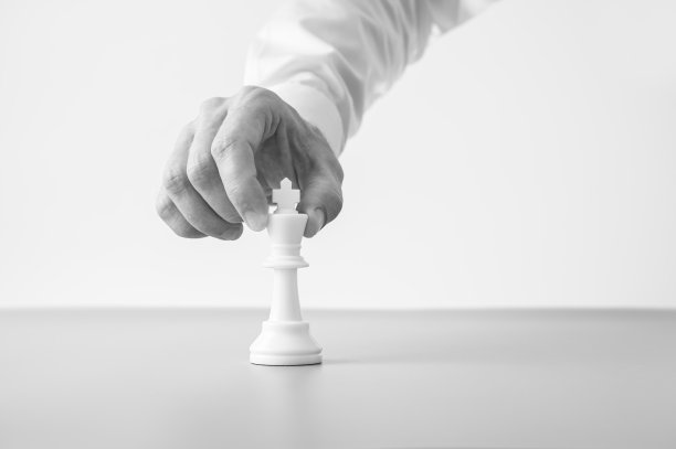 灰度图像的商人把一个国王象棋人物在桌子上图片下载