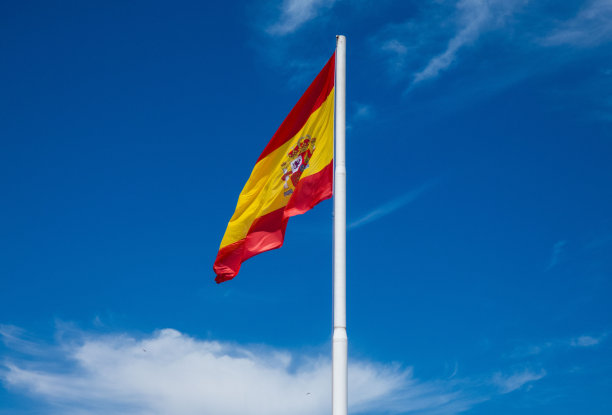 蓝天迎风飘扬的西班牙国旗图片下载