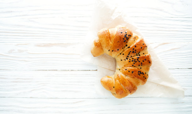 羊角面包上白色纹理的木质背景顶视图，舒适和美味的早餐。质朴的背景与复制空间图片下载