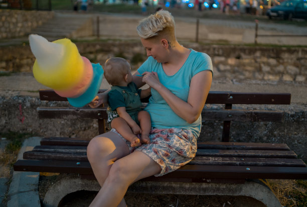 快乐的妈妈和宝宝在游乐园晚上的肖像图片下载