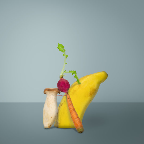 创造性的水果和蔬菜。蓝色背景上的香蕉、萝卜、蘑菇和胡萝卜图片下载