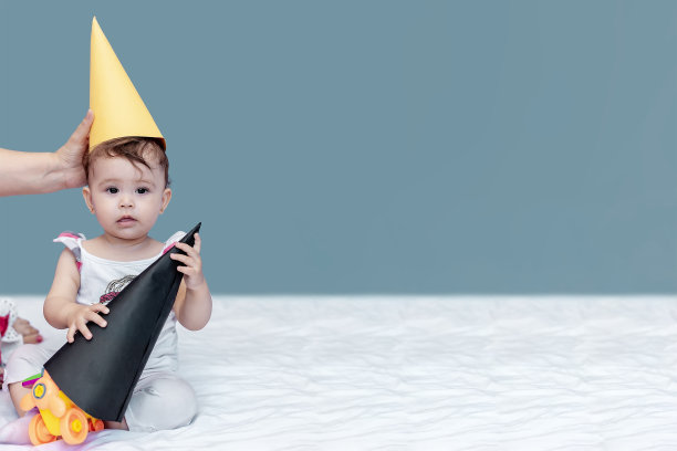 庆祝一周岁生日的女宝宝，玩生日帽图片下载