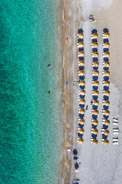 从无人机的角度看，海滩海岸线上的日光浴床图片下载