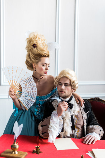 美丽的维多利亚女人拿着扇子，站在傲慢的男人旁边，拿着羽毛靠近纸图片下载