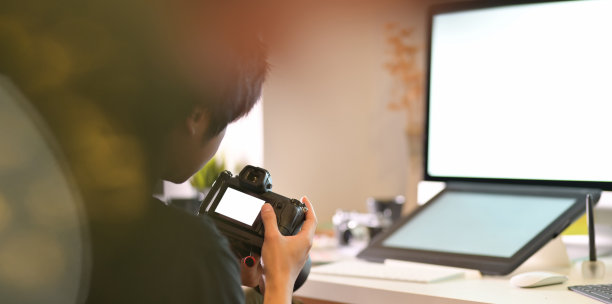 有动机的男性摄影师正在检查他的相机图片下载