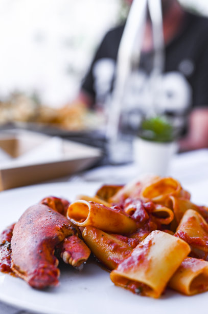 带刺龙虾和番茄酱的意大利面。餐厅的海鲜午餐和一杯白葡萄酒。蓝色和选择性的聚焦在照片上。图片下载