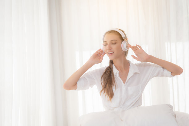 女人用耳机听音乐放松。图片下载