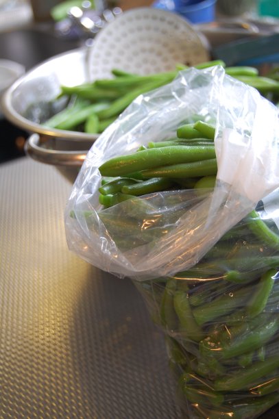 在一个有豆子的滤锅前，近距离观察一袋焯过的青豆。图片下载