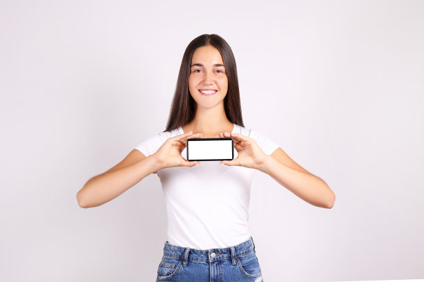 年轻的黑发女孩在灰色的背景下有着有趣的面部表情。图片下载