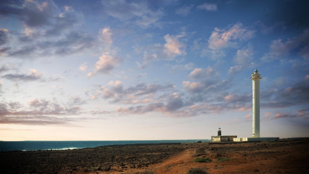 兰萨罗特岛美丽的海岸线，你可以看到一座宏伟的灯塔图片下载