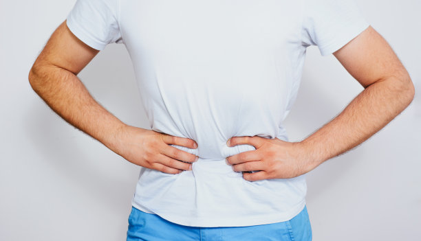 男人腹痛。男人正捂着他的肚子，他感到很痛。肠胃问题,消化不良。图片下载
