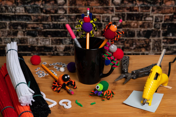 有趣的万圣节工艺品。用绒球和管道清洁器做的蜘蛛。铅笔。家人和孩子一起制作工艺品。所有的用品和乐趣在一个镜头!图片下载