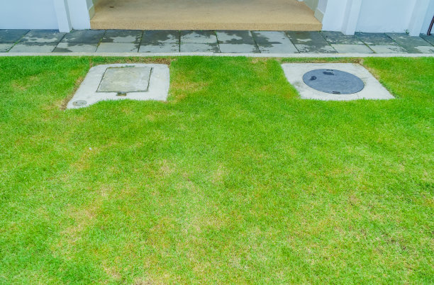 标志水箱和排水水箱在绿色的草地上。将处理池放置在草地上。图片下载