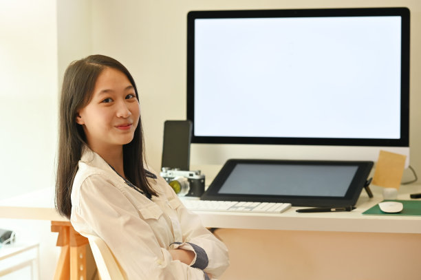 年轻的平面设计师坐在镜头前。图片下载