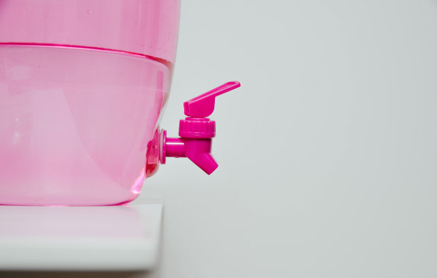 一个男人从饮水机里倒水。生活方式的概念，喝水，口渴。图片下载