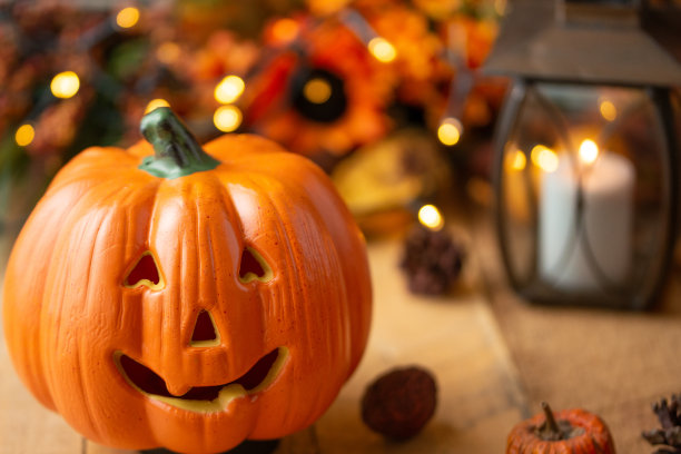万圣节南瓜与树叶在一个旧木桌与发光灯和一个旧灯。秋天的心情和大气的照片图片下载