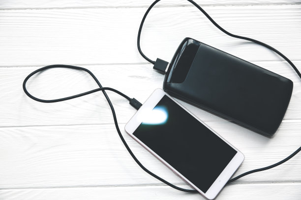 黑色电源与usb和智能手机在木制背景。现代信息技术照片。图片下载