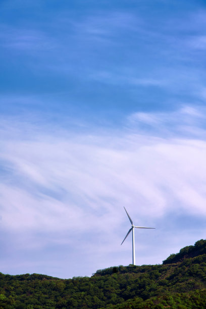 蓝天背景下山顶上的风力涡轮机图片下载