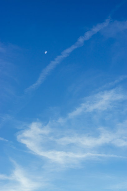 美丽的蓝天和月亮和有趣的白色，精致，半透明和纤维状的冰晶面纱在早晨的阳光图片下载