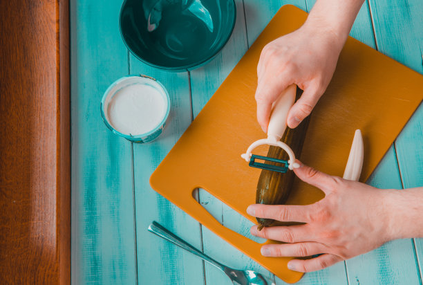 一个男人正在采摘绿色黄瓜的俯视图。准备沙拉的概念，沙拉和晚餐。图片下载