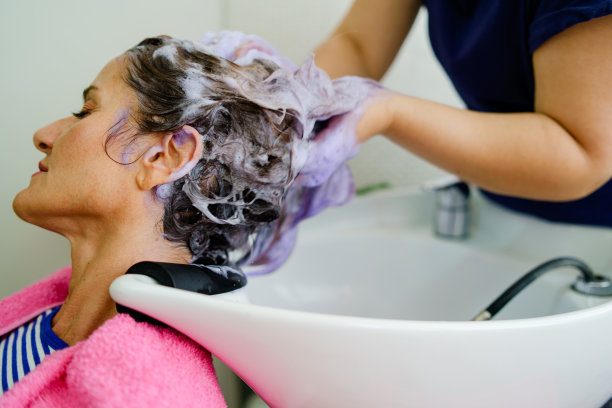 美发师在美发厅为一位女士洗头图片下载