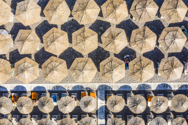 从无人机的角度看，完美的海滩对称，日光床和遮阳伞被走道分割图片下载