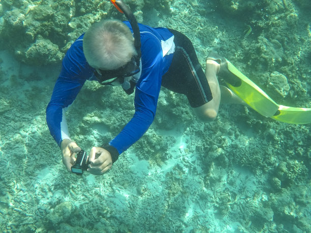 在马尔代夫热带水域用水下相机潜水的资深男子的水下照片图片下载