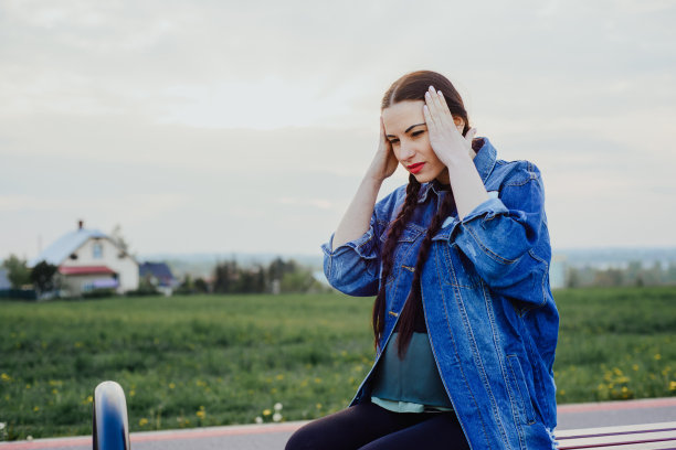 孕妇头痛。女人紧紧地抱着她的头，她感到很痛。图片下载