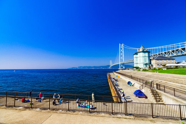 夏日清晨明石海峡大桥背景中的家庭垂钓者景观图片下载