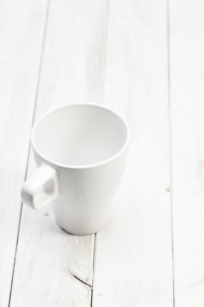 白色的空杯子放在白色的木桌上图片下载