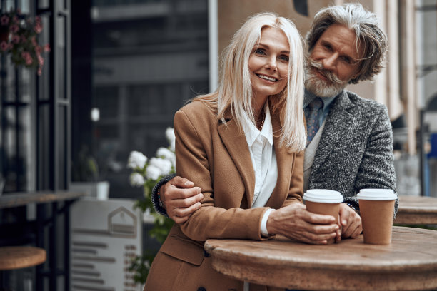 微笑的夫妇拥抱在咖啡厅高桌子库存照片图片下载