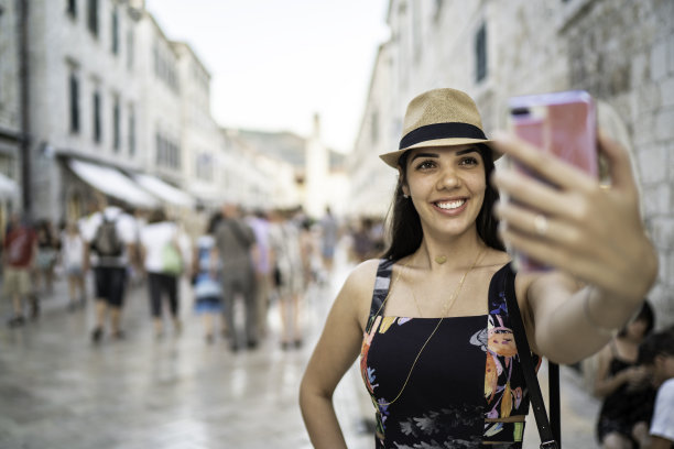 一个年轻的女游客在马路中间自拍图片下载