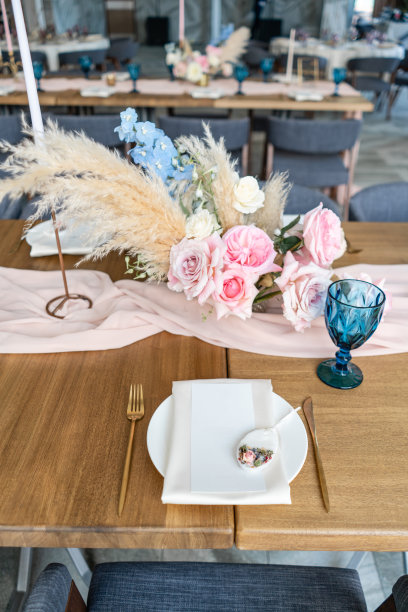 豪华晚餐在餐厅的宴会。美丽精致的婚宴装饰。宴会餐桌上有米黄色的桌布，盘子和烛台与蜡烛。图片下载