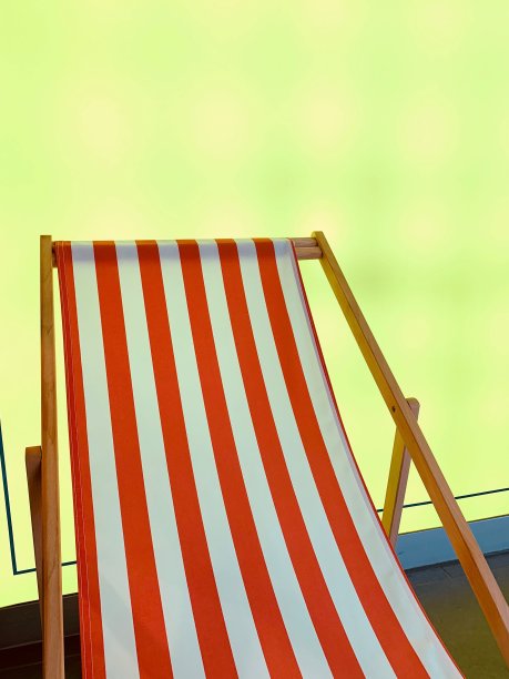 红色条纹帆布躺椅上的绿黄背景图片下载