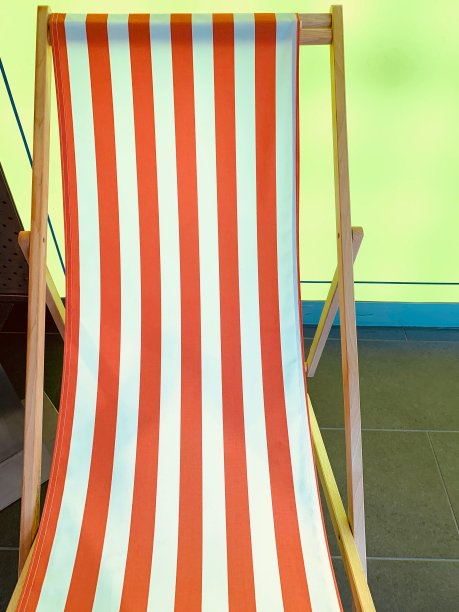 红色条纹帆布躺椅上的绿黄背景图片下载
