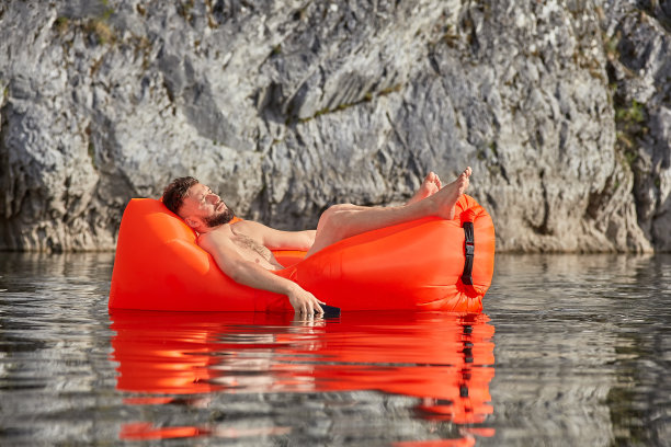白人男人睡在沙发上玩手机。图片下载