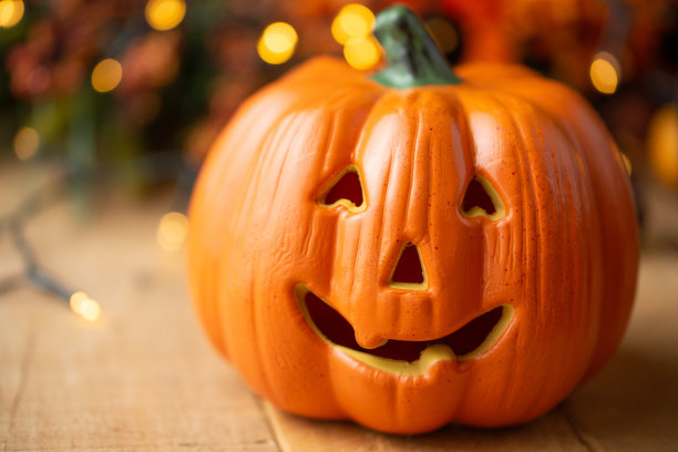 万圣节南瓜与树叶在一个旧木桌与发光灯和一个旧灯。秋天的心情和大气的照片图片下载