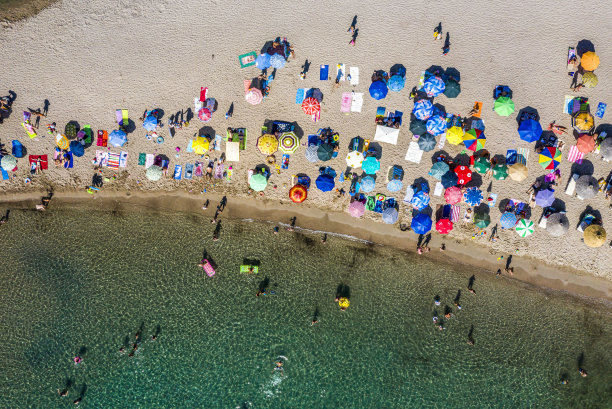 受污染的海滩海岸，雨伞和日光浴床从上面的无人机图片下载