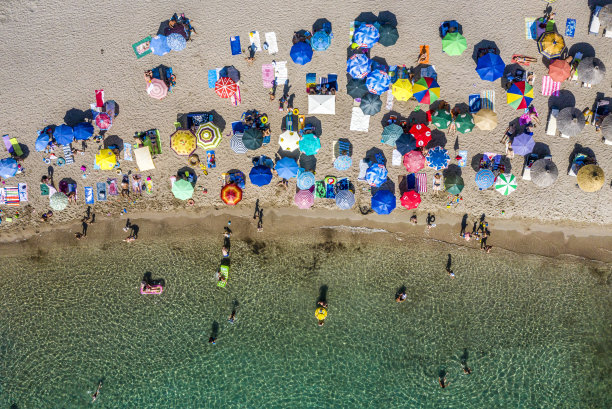 翡翠海的海岸线，和一个拥挤的海滩，从无人机的角度拍摄图片下载