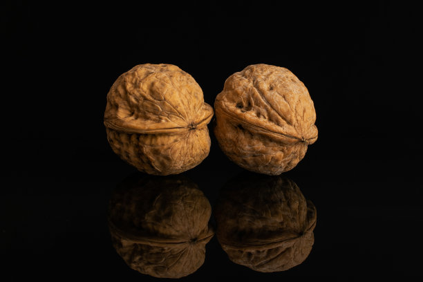 孤立在黑色玻璃上的成熟棕色核桃图片下载
