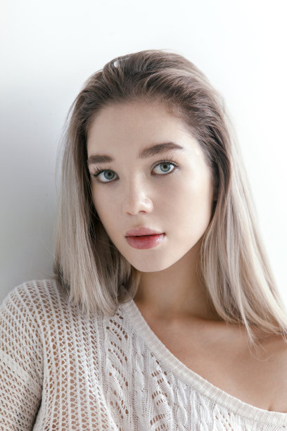 年轻美丽的金发碧眼女人在针织米色上衣自然美丽图片下载