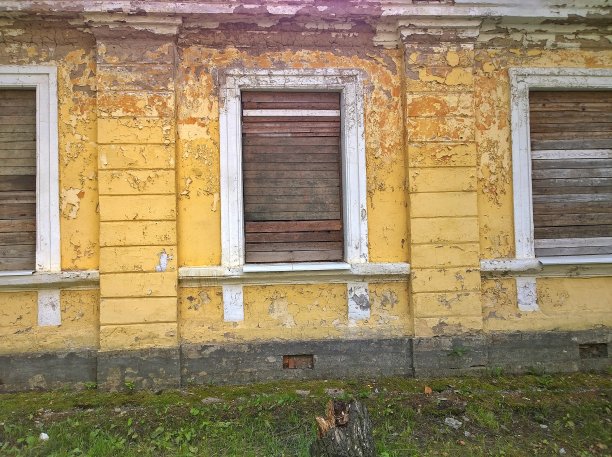 一座废弃的、带有木制百叶窗的年久失修的房子。贫穷、破坏、经济和金融危机的概念。图片下载